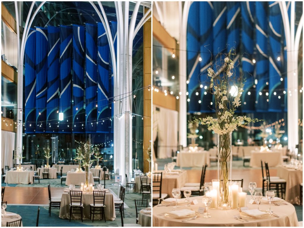 Reception layout with market lights, square and round tables with tall centerpieces inside the Indianapolis central library