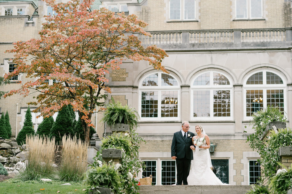 The bride and her father stand at the top of the outdoor steps at Laurel Hall before they start walking down the aisle