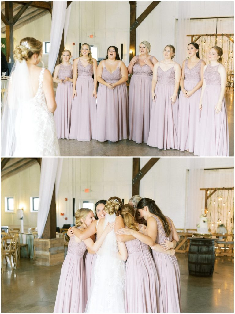 The bride does a first look with her bridesmaids inside the main event barn at white willow farms in indiana
