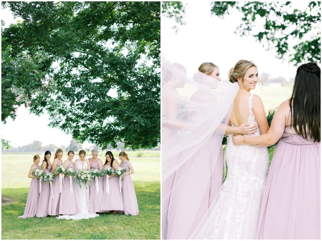 The bride and her bridesmaids take photos under mature trees on the white willow farms property 
