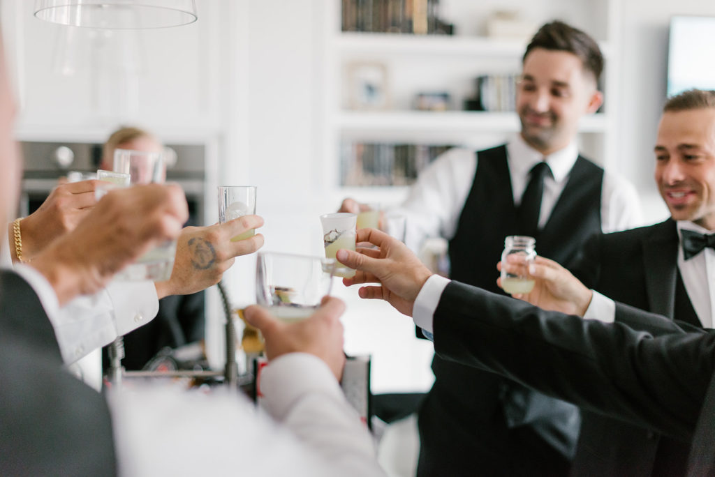 The groom and his groomsmen toast in the getting ready room before the day begins