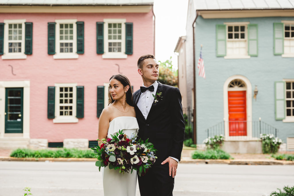 The bride and groom take a portrait in front of color historic homes around Gratz Park in Lexington