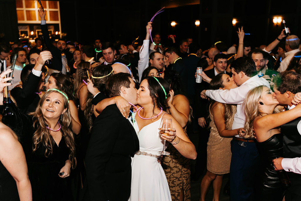 bride-and-groom-kiss-at-midnight-at-their-holiday-wedding-reception-on-new-years