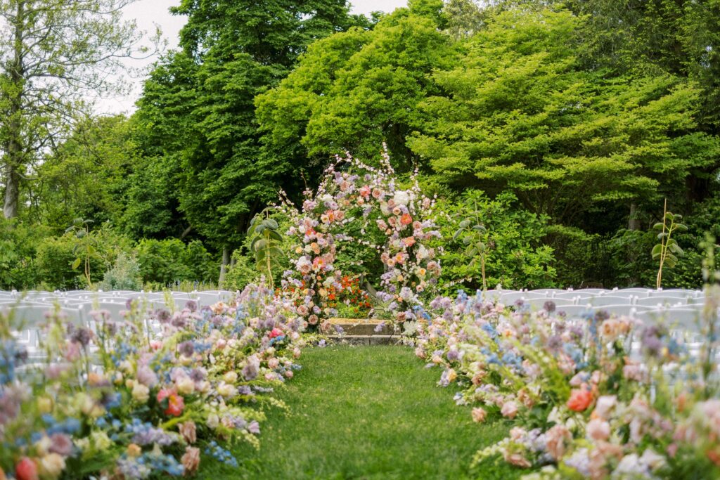 yew-dell-botanical-garden-wedding-ceremony-set-up-with white chairs and colorful flowers