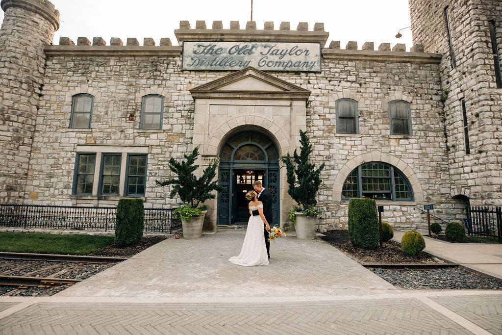 bride and groom at the entrance of castle and key distillery in Kentucky