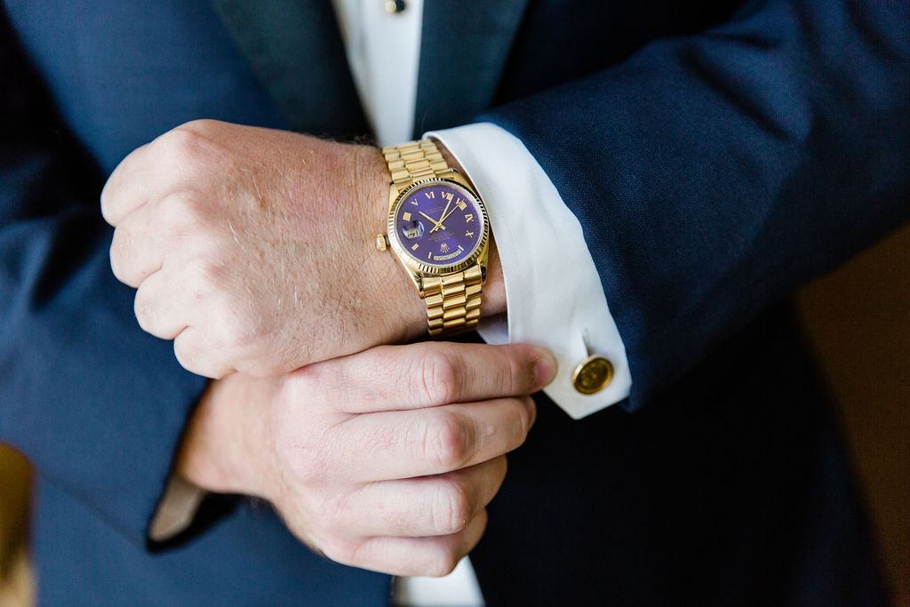 The Groom's gold and purple watch with matching gold cuff links.