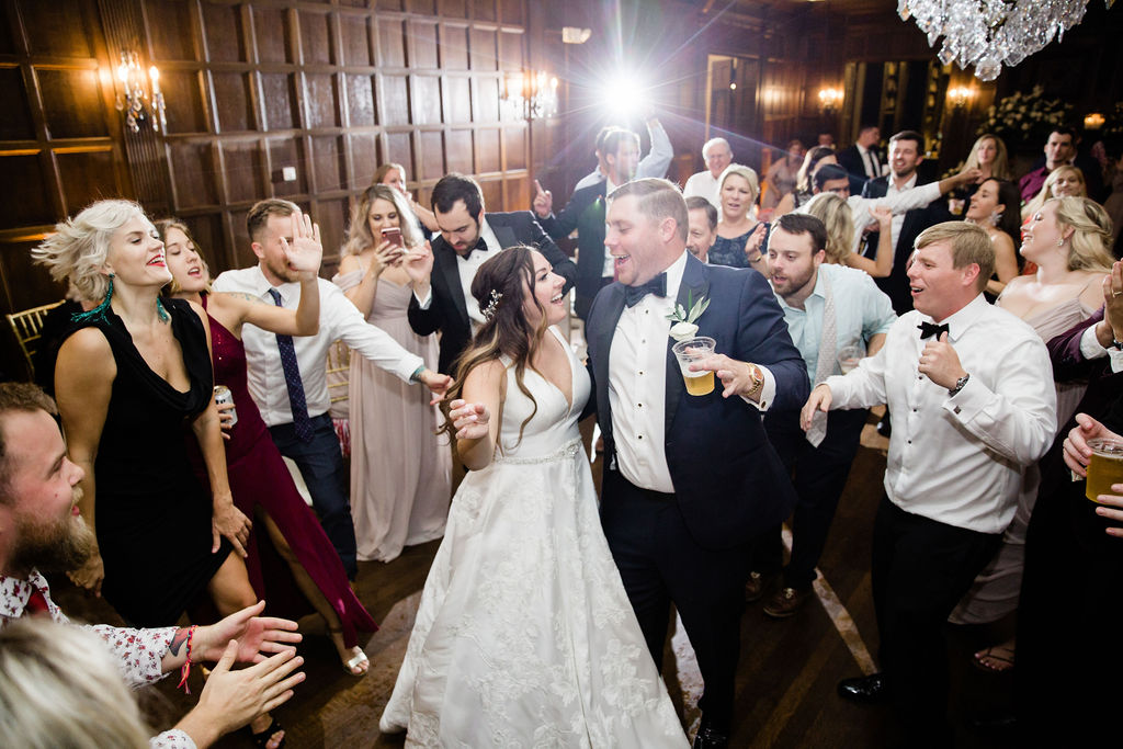 The bride and groom happily dancing in the middle of all of their guests