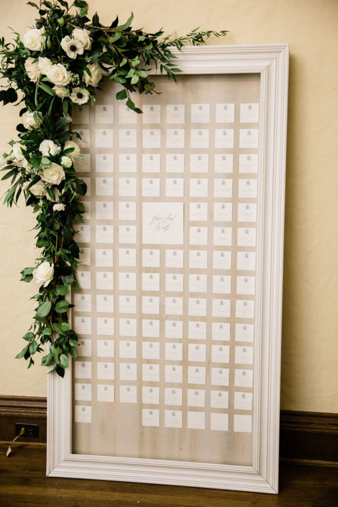 Framed seating chart with fresh floral at the Hurstbourne Country Club