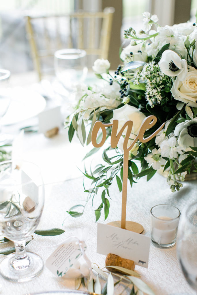A gold table number one sign on a reception table 