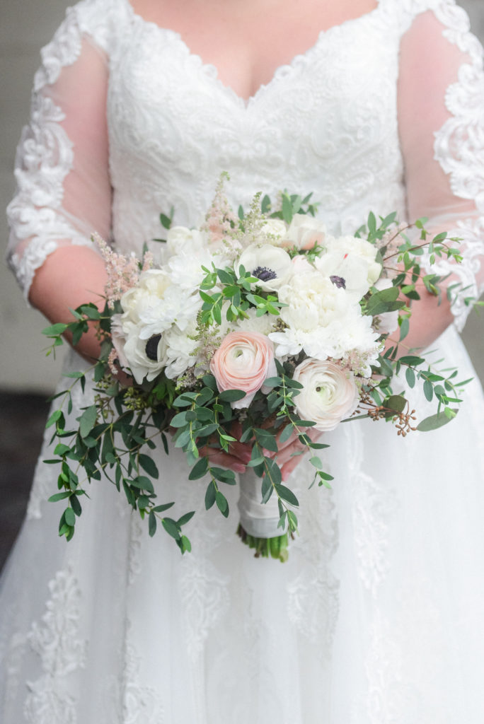 the bride holding her white, pink, and green bouquet