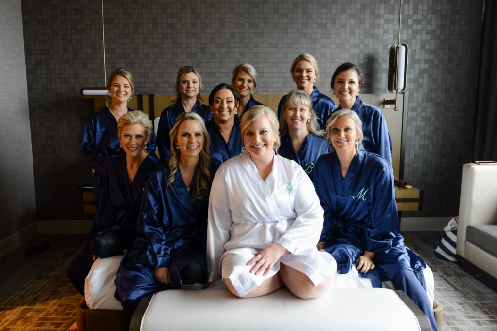 The bride and her bridesmaids take a group photo in their getting ready robes 