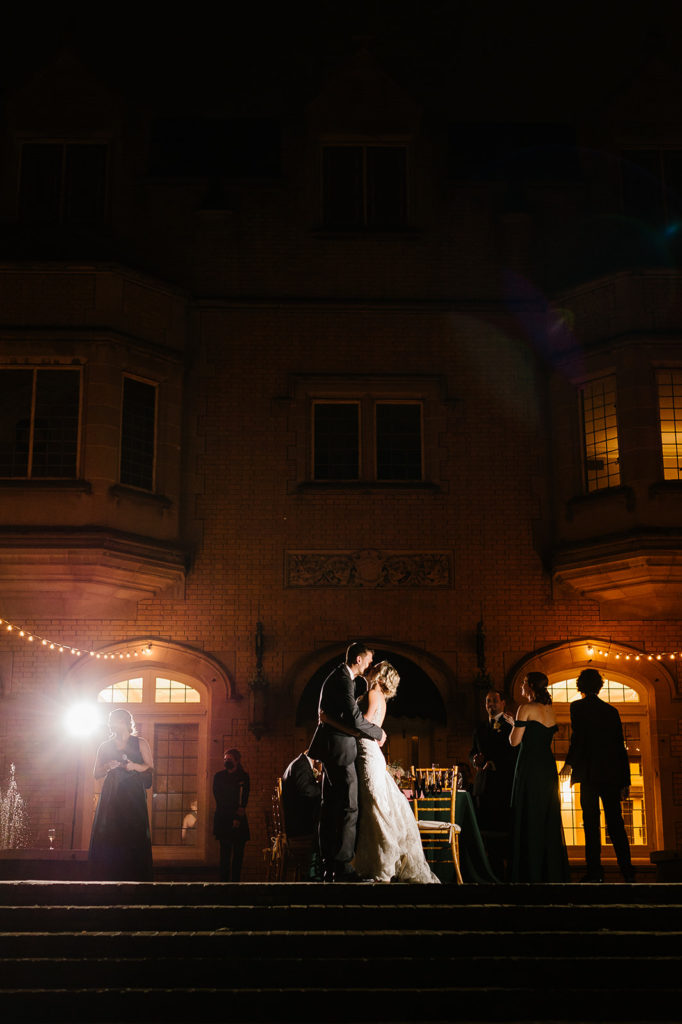 the bride and groom kiss while dancing on the terrace at Laurel Hall in Indianapolis Indiana