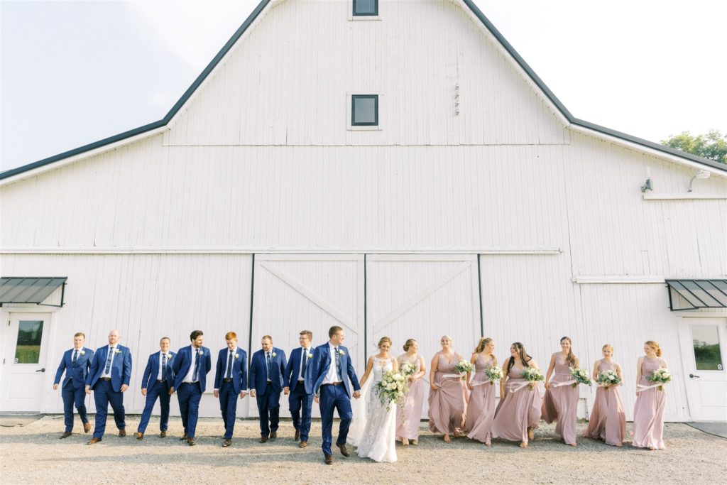 The wedding pary take photos outside the wedding barn at white willow farms 