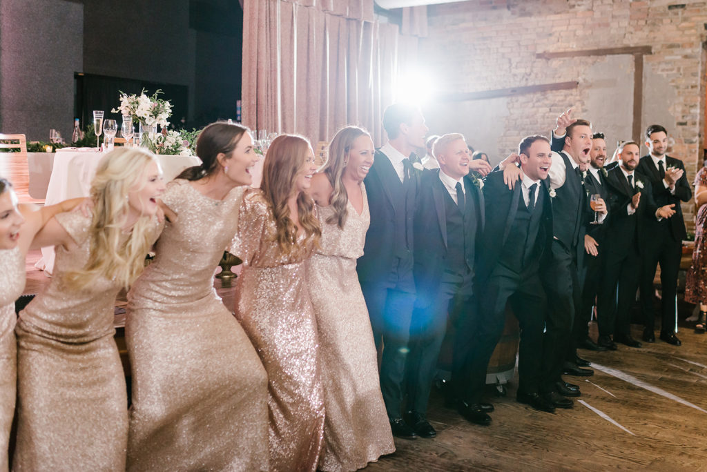 the wedding party dance together at the reception in the city winery in chicago
