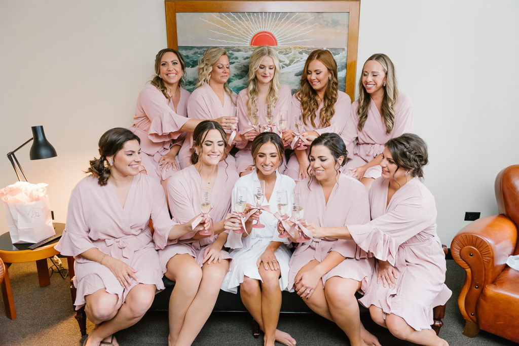 The bridal party in their getting ready robes, cheers with champagne before getting ready