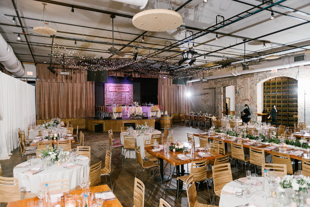 Inside the city winery in chicago with exposed brick and ceiling, and decorated reception tables