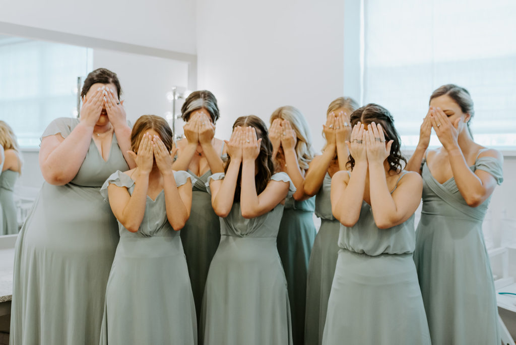The bridesmaids cover their eyes in anticipation for the bride's first look at daniel's vineyards