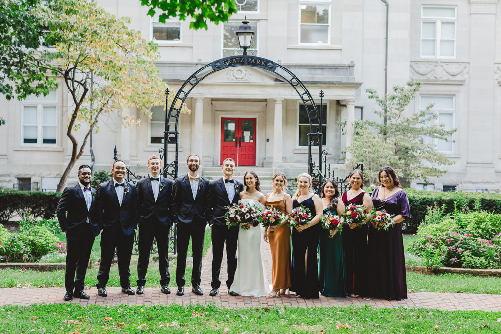 the entire wedding party takes a group photo in front of the Gratz Park gate in Lexington