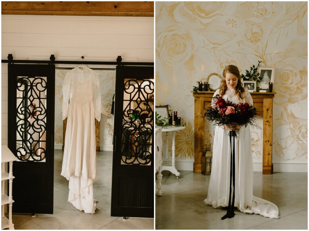 the brides wedding dress hanging from black slide doors and the bride holding her bouquet of red flowers inside the bridal suite