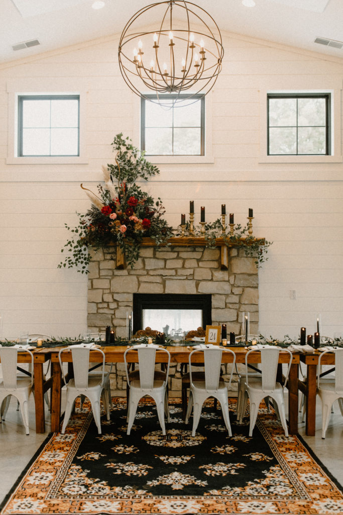 the head table in front of the fireplace at the wilds wedding venue