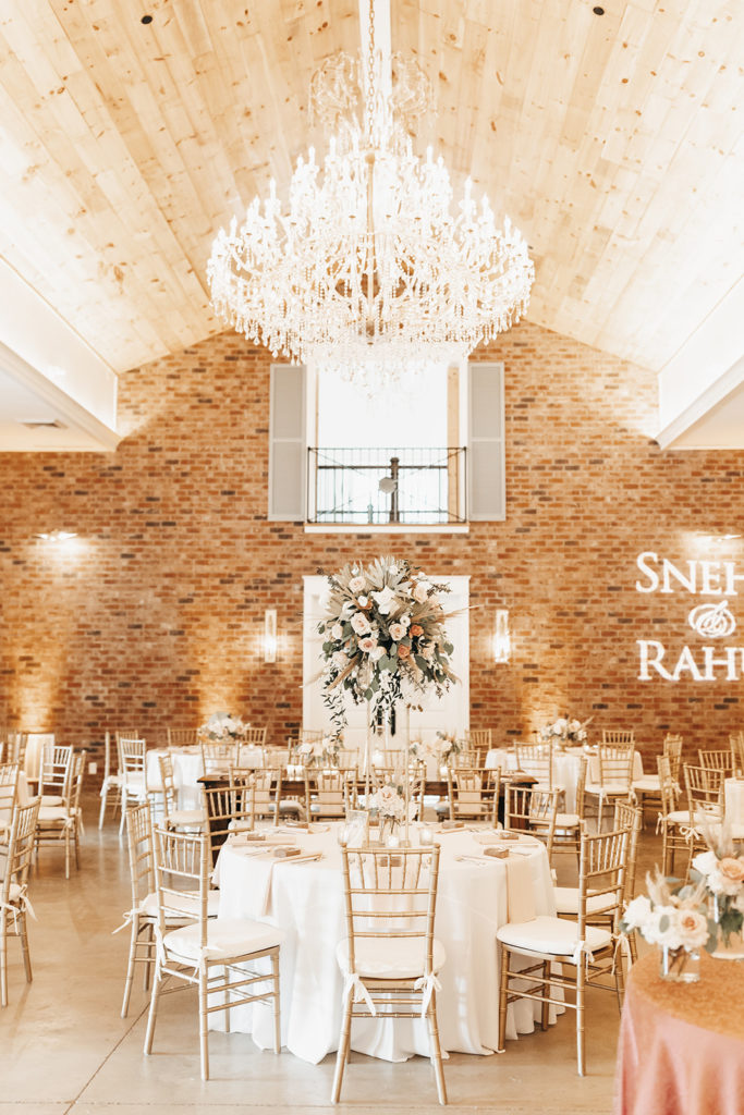 the reception design with large chandelier, bright white and neutral floral and linen give the perfect boho design.