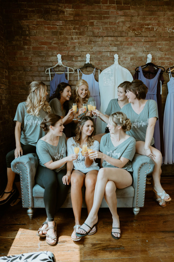 bridal party cheers with mimosas in the bridal suite before getting ready