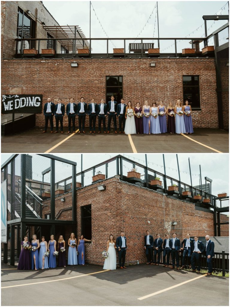 The wedding party group photos outside the industrial Biltwell event center building in the parking lot 
