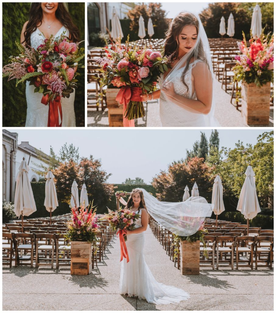 The bride in her white dress and veil standing in front of the aisle in the courtyard of The Refinery
