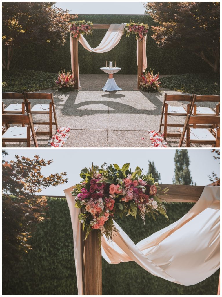 This wood arch at the alter had draping and flower accents. There were flower accents one at each base and a small white table in the center with two candles. 