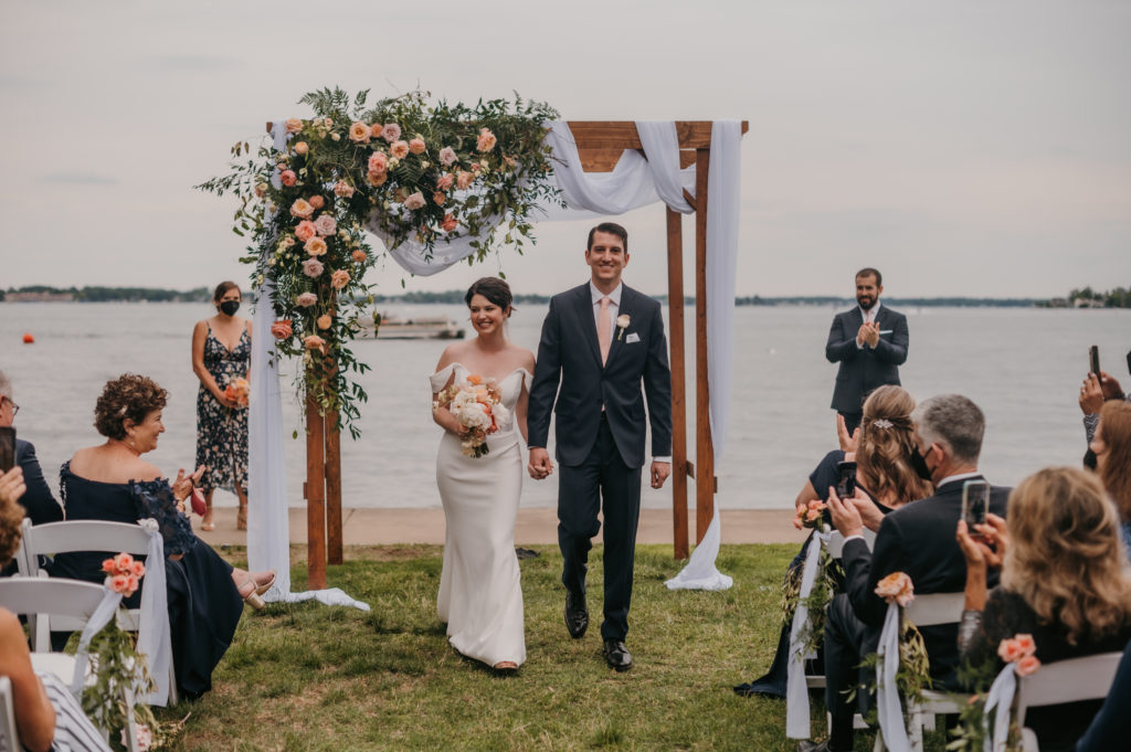 bride and groom walk back down the aisle after they are announced as husband and wife 
