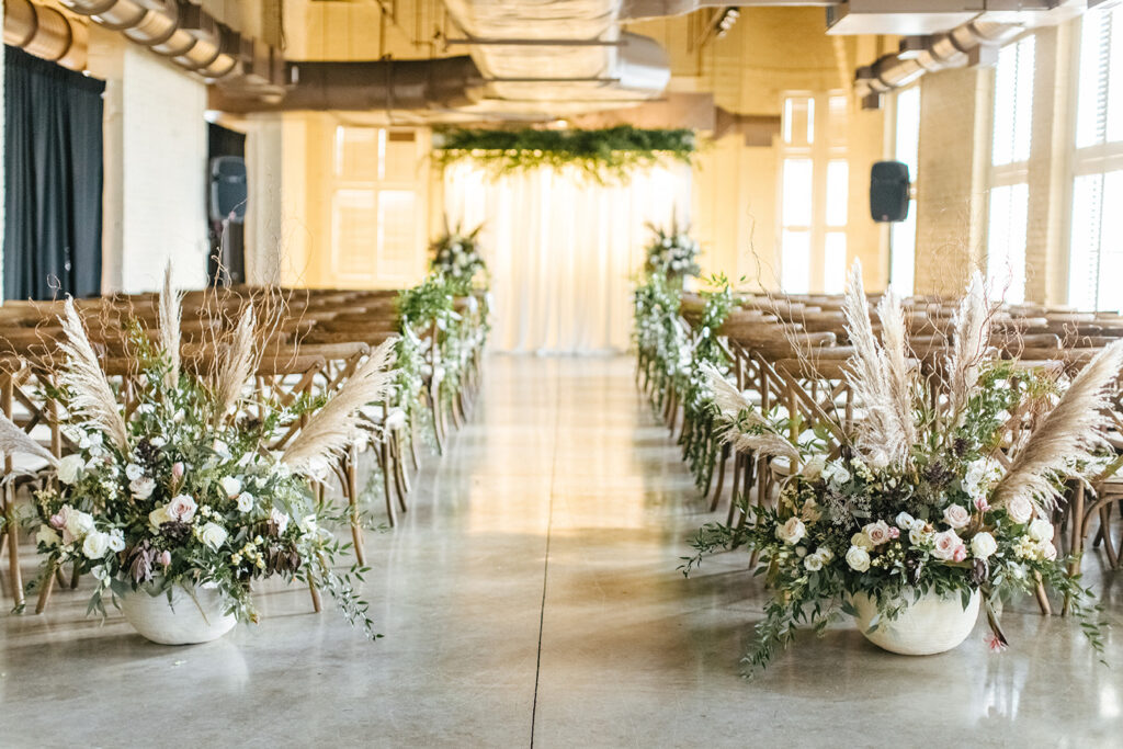 Frazier history museum indoor wedding ceremony with boho inspired floral arrangements and wooden cross back chairs 